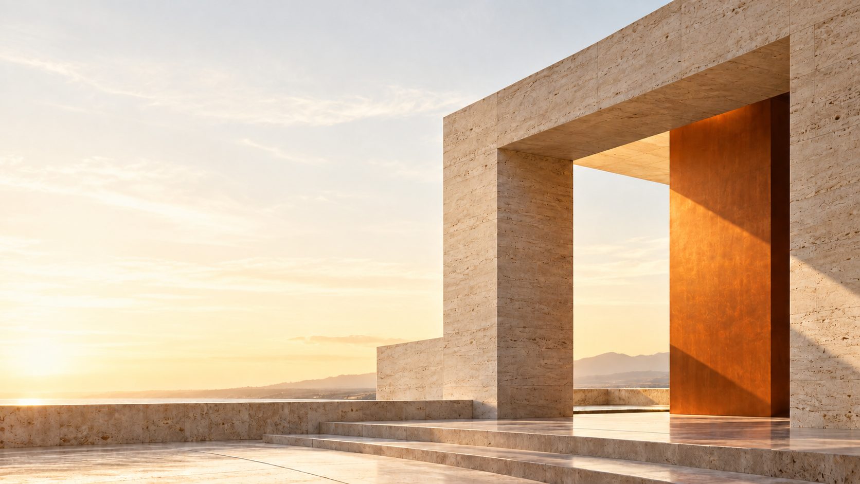 A travertine portal framing hazy mountains at sunset